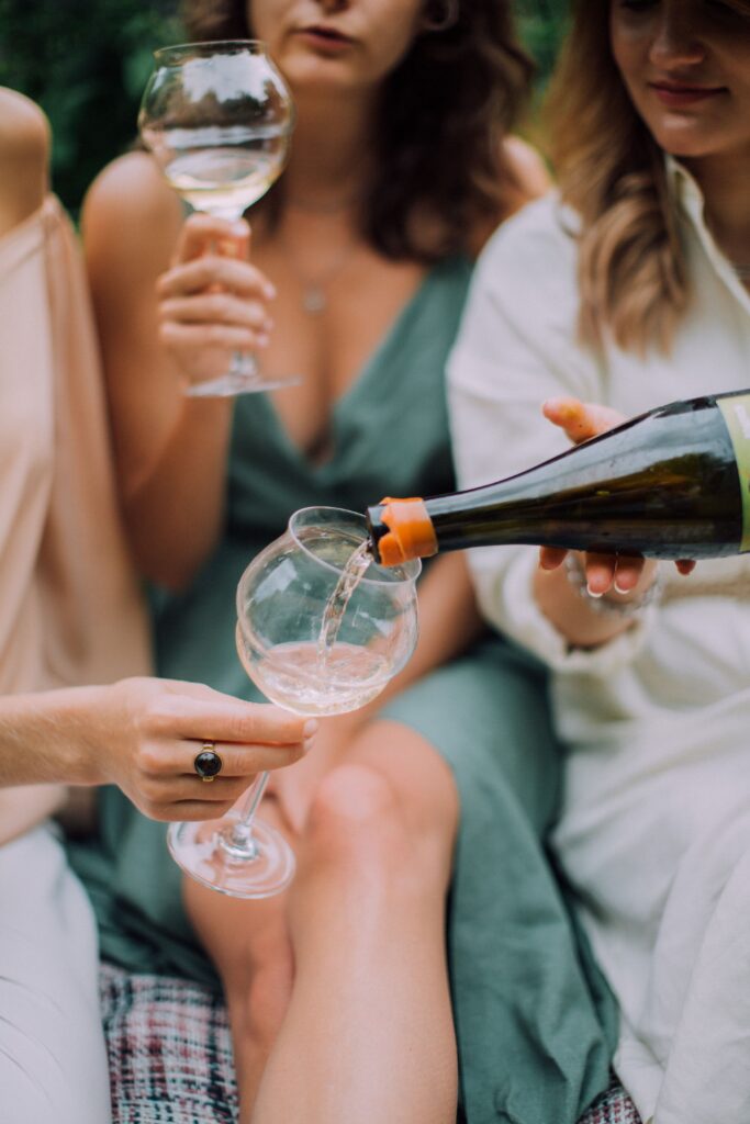 Women pouring wine in the summer.